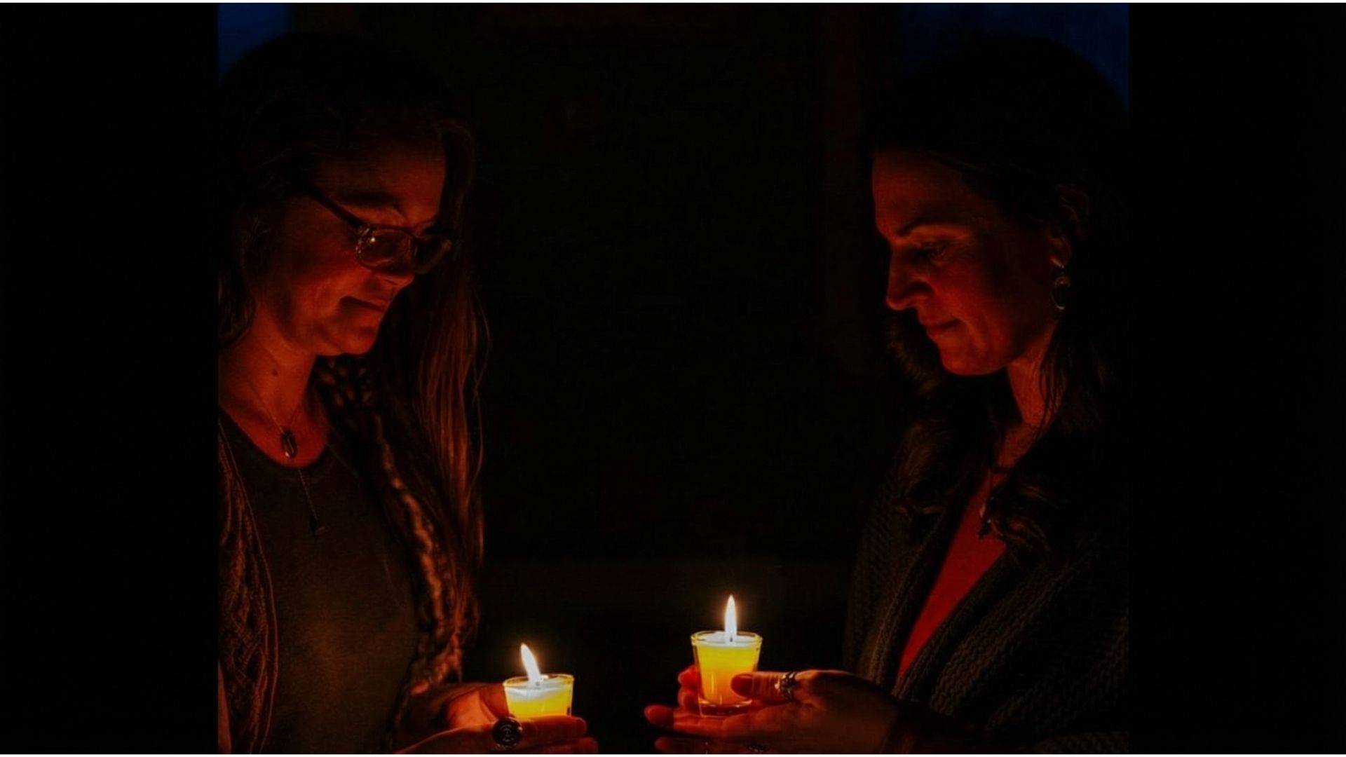 Two people sharing candlelit meditation